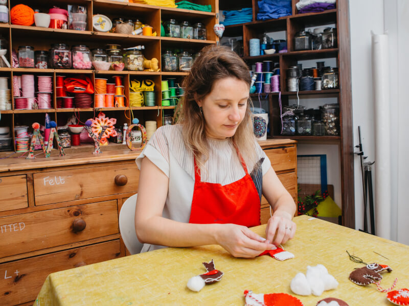 Woman wearing apron sewing
